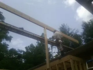 Carpenter setting a ridge beam over a new addition frame — Ice Dam Removal by Roofing Brothers in Ramsey