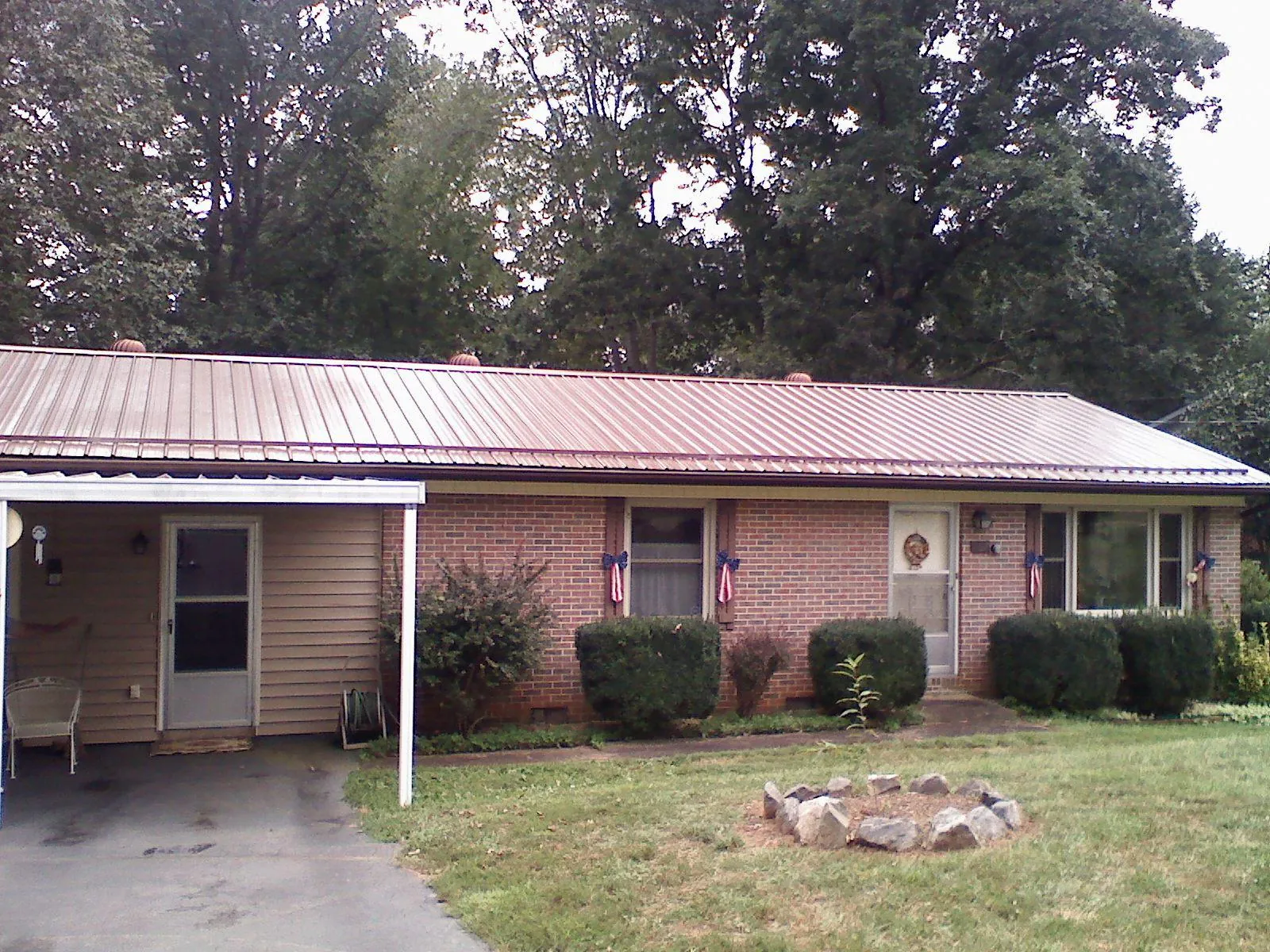 Bronze metal roof and carport on a brick ranch home — Roof Repair work by our crew in Ramsey